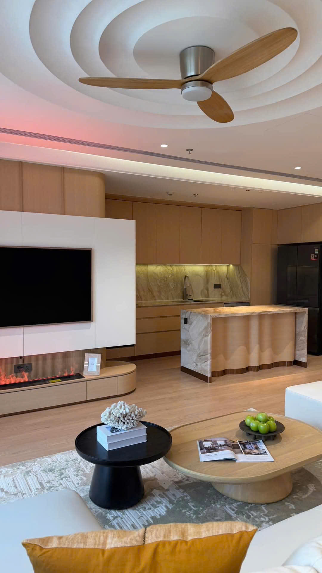 Không gian bếp mở với quầy bar đá và đèn trần hiện đại.