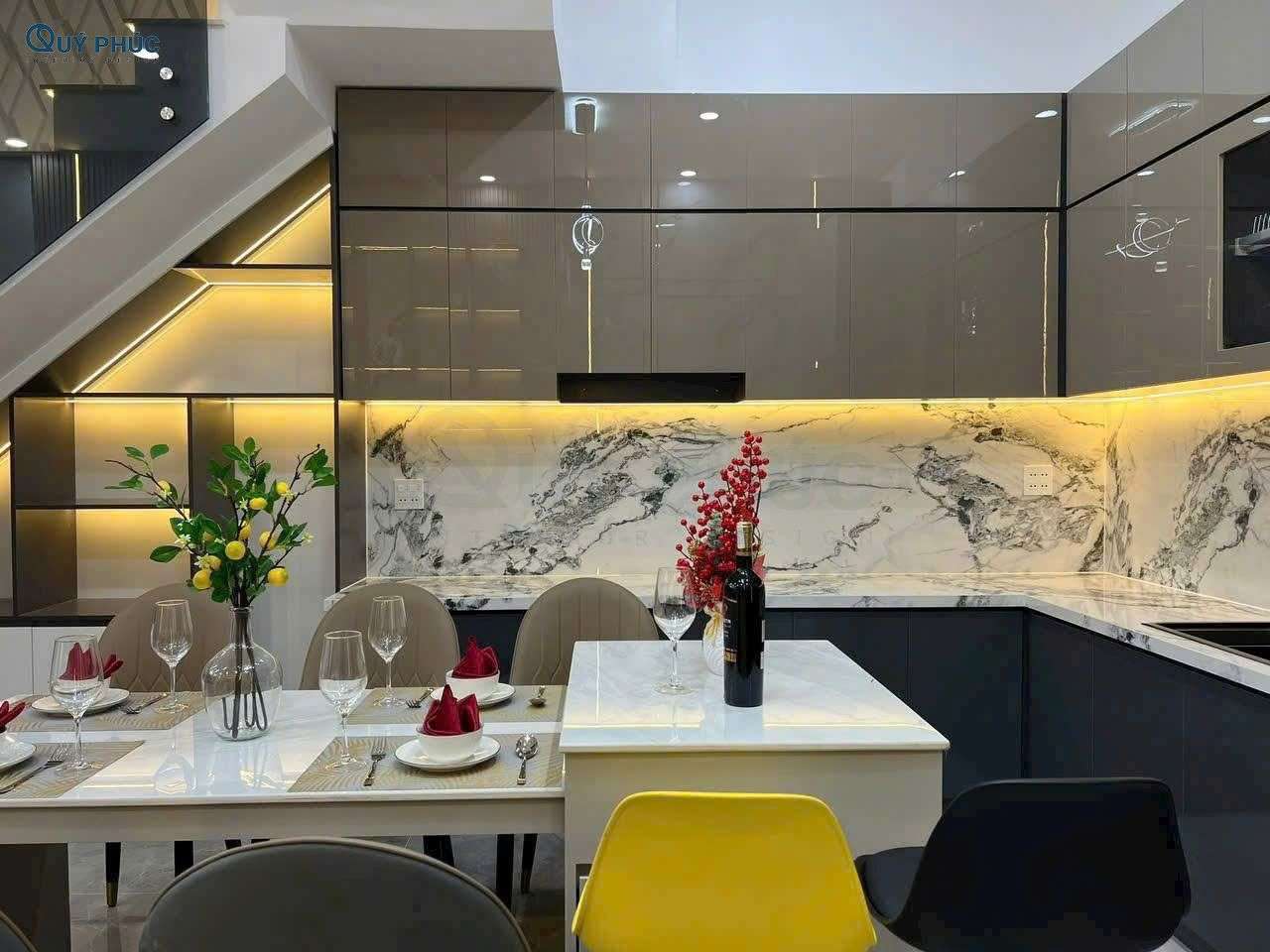 Thi Công Nội Thất Phòng Bếp 13 Không gian bếp hiện đại với backsplash vân đá tự nhiên và bàn đảo tích hợp.